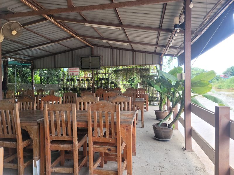 โต๊ะไม้ริมด้านที่เปิดโล่งของศาลา ติดกับน้ำ