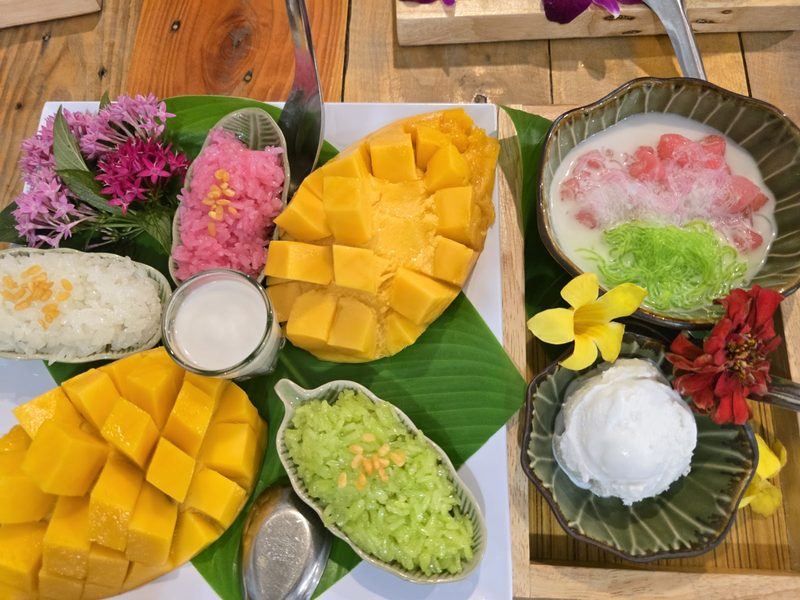 ข้าวเหนียวมะม่วง ข้าวเหนียวสี และขนมไทยจัดบนใบตอง